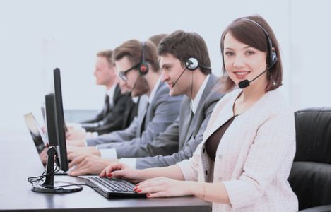 Servizi di segreteria, assistenza clienti e domiciliazione per aziende negli USA - L'immagine mostra un team di operatori di call center in abbigliamento professionale, seduti davanti ai computer e dotati di cuffie con microfono. In primo piano, una donna sorridente rappresenta il supporto amministrativo e il customer service. Us Company Advisor offre servizi di domiciliazione aziendale, segreteria virtuale e gestione clienti per le imprese italiane che desiderano stabilire una presenza professionale negli Stati Uniti.