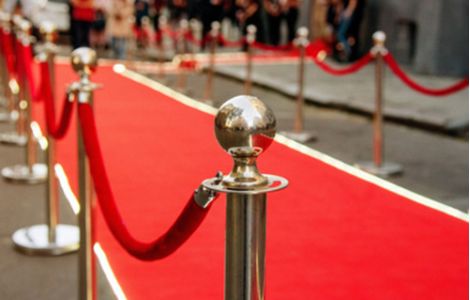 Organizzazione di eventi aziendali e fiere di settore negli USA - L'immagine mostra un elegante tappeto rosso delimitato da paletti con corde, simbolo di eventi esclusivi, fiere e networking di alto livello. Us Company Advisor supporta le aziende italiane nell'organizzazione di eventi, partecipazione a fiere internazionali e strategie di branding per il mercato statunitense.