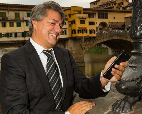 L'immagine è la copertina di un'edizione speciale della rivista "Entrepreneur Daily Mag". Presenta Paolo Odierna e due altri professionisti in un'ambientazione elegante con un muro di mattoni a vista, trasmettendo un senso di professionalità e raffinatezza.  Paolo Odierna è posizionato sulla destra, indossando un abito marrone chiaro con camicia bianca, e ha un'espressione seria e sicura. Accanto a lui, alla sinistra dell'immagine, c'è un altro uomo in giacca marrone scuro e camicia azzurra, che guarda direttamente in camera con un'aria determinata. Seduta al centro c'è una donna in blazer bianco, con una mano sul mouse e un'espressione accogliente e sicura.  Il testo della copertina sottolinea il ruolo di Paolo Odierna nel progetto Visionarium, che intreccia arte, design, moda, tecnologia e gastronomia per ridefinire gli spazi lifestyle con un tocco di sofisticazione italiana.  L'estetica dell'immagine e la postura dei soggetti trasmettono un senso di leadership, innovazione e successo imprenditoriale, enfatizzando il contributo italiano al mondo del business e del design.
